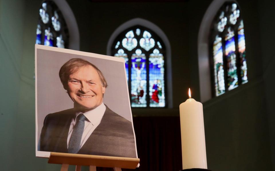 A candle and a portrait of British MP David Amess,at the church of St Michael's and All Angels - Chris Radburn/Reuters
