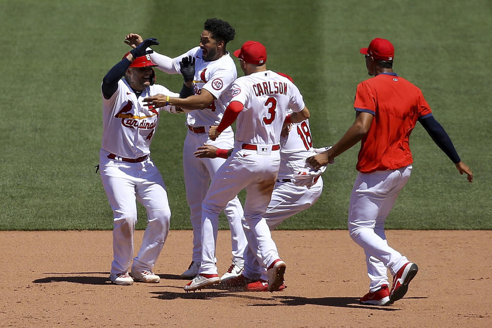 St. Louis Cardinals' Yadier Molina, left, is congratulated by teammates after hitting a walk-off RBI single during the ninth inning of a baseball game against the Miami Marlins Wednesday, June 16, 2021, in St. Louis. (AP Photo/Scott Kane)