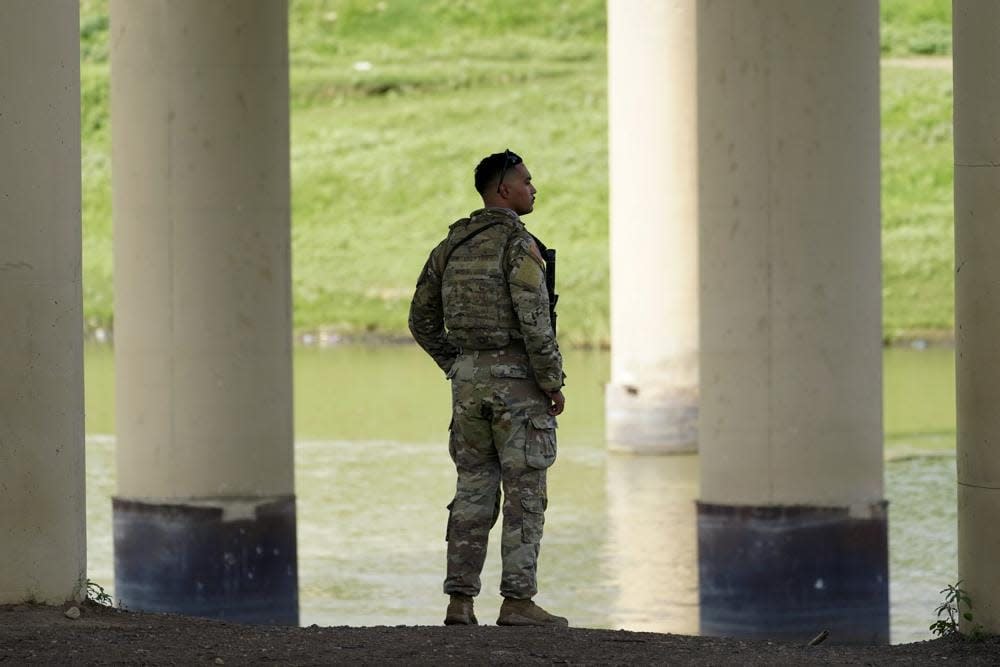 FILE – A member of the Texas National Guard looks across the Rio Grande to Mexico from the U.S. at Eagle Pass, Texas, on Aug. 26, 2022. At least eight migrants were killed as dozens attempted a hazardous crossing of the Rio Grande near Eagle Pass, Texas, officials said Friday, Sept. 2, 2022. U.S. Customs and Border Protection reported that it responded to the report a day earlier. (AP Photo/Eric Gay, File)