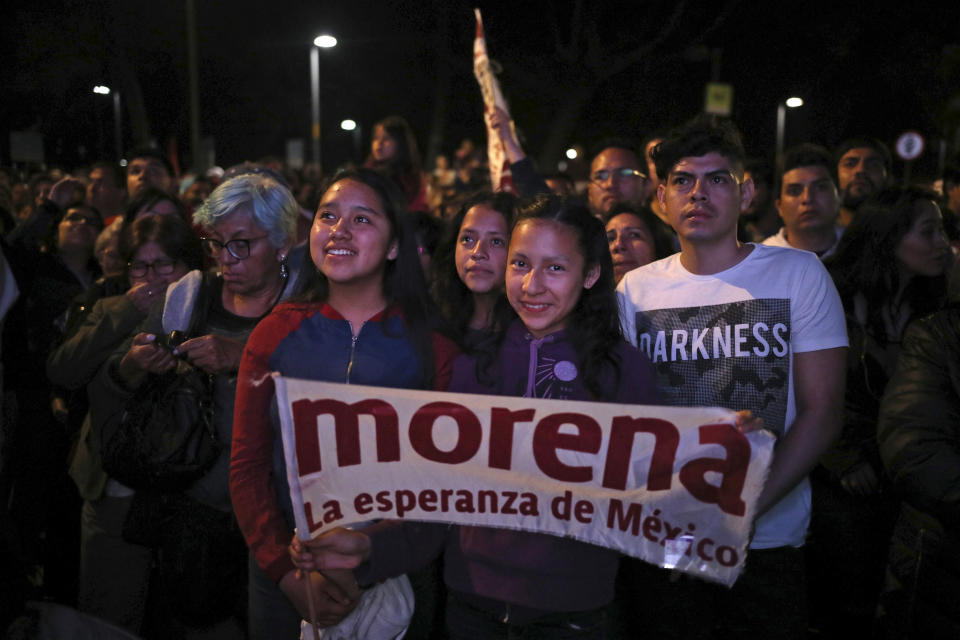 FILE - Supporters of presidential candidate Andres Manuel Lopez Obrador, of the Morena party, wait for his arrival at Mexico City's Zocalo plaza, July 1, 2018. With Morena now dominant in Mexico, the biggest question in politics has become what kind of internal divisions will hit the party basically built around López Obrador, when he retires in 2024. (AP Photo/Emilio Espejel, File)