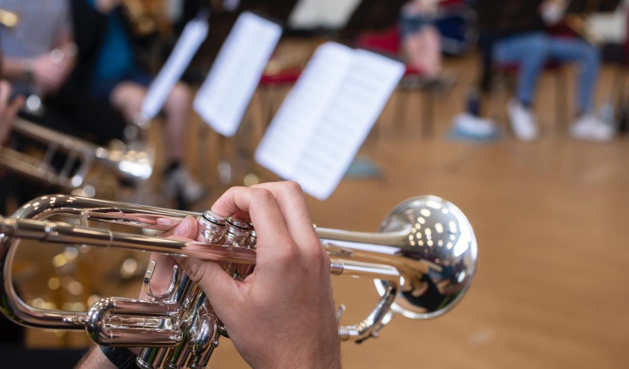  A closeup on a student playing a trombone. 