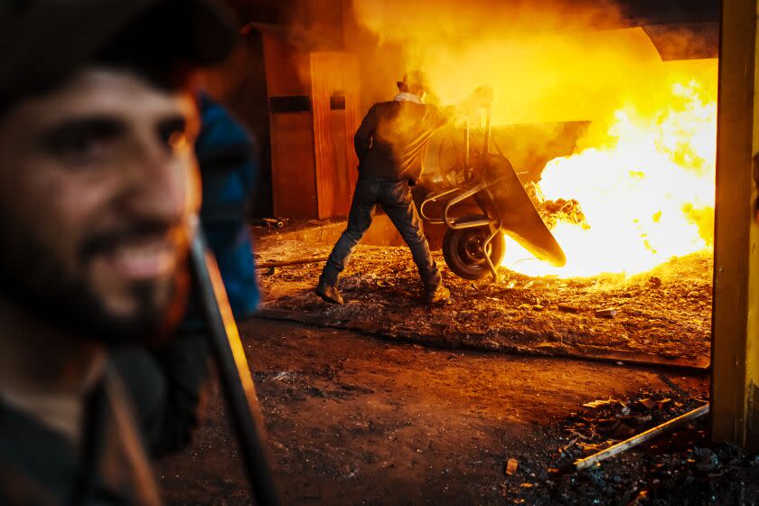 KABUL, AFGHANISTAN -- SEPTEMBER 7, 2022: Workers toss recycled metals into a furnace to burn on a production line at a steel plant that Yu Minghui, 51-year-old entrepreneur from China, partially owns and operates, in Kabul, Afghanistan, Wednesday, Sept. 7, 2022. The Taliban takeover of Afghanistan has upended the working lives of hundreds of thousands of people and made most international businesses in the country race for the exit, but Chinese entrepreneurs see an opportunity. With the West focused on the Ukraine war and Washington refusing to deal with a Taliban-led state, Beijing too sees an opportunity, to extend influence through commercial ties, use them to forge a stable regional order and demonstrate that its brand of economic diplomacy N buttressed by a committed policy of noninterference in political affairs N can achieve success where WashingtonOs 20-year-misadventure in Afghanistan could not. (MARCUS YAM / LOS ANGELES TIMES)