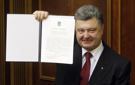 Ukraine's President Petro Poroshenko shows a signed landmark association agreement with the European Union during a session of the parliament in Kiev, September 16, 2014. REUTERS/Valentyn Ogirenko