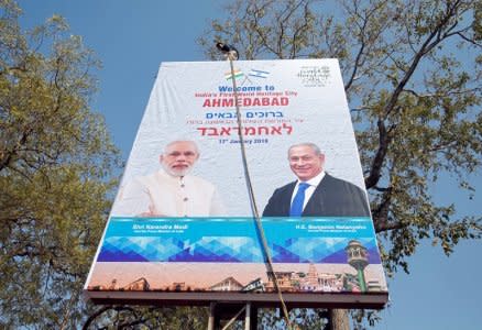 A man installs a hoarding ahead of the visit of Israeli Prime Minister Benjamin Netanyahu in Ahmedabad, India, January 16, 2018. REUTERS/Amit Dave