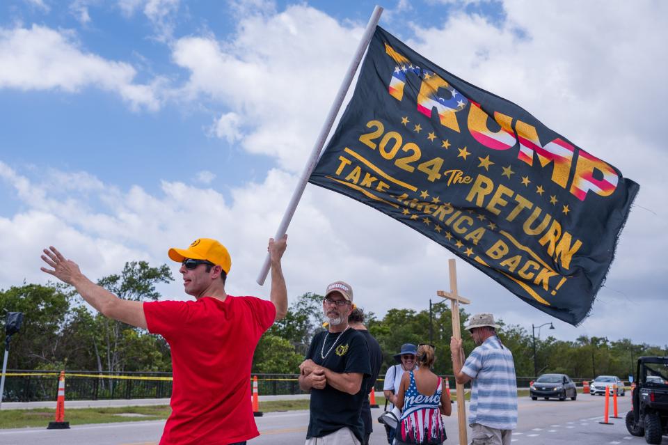 Supporters of former President Donald Trump wave to traffic while standing on the bridge section of Southern Boulevard leading towards Mar-A-Lago, former Trump's residence on Saturday, April 1, 2023, in Palm Beach, FL.