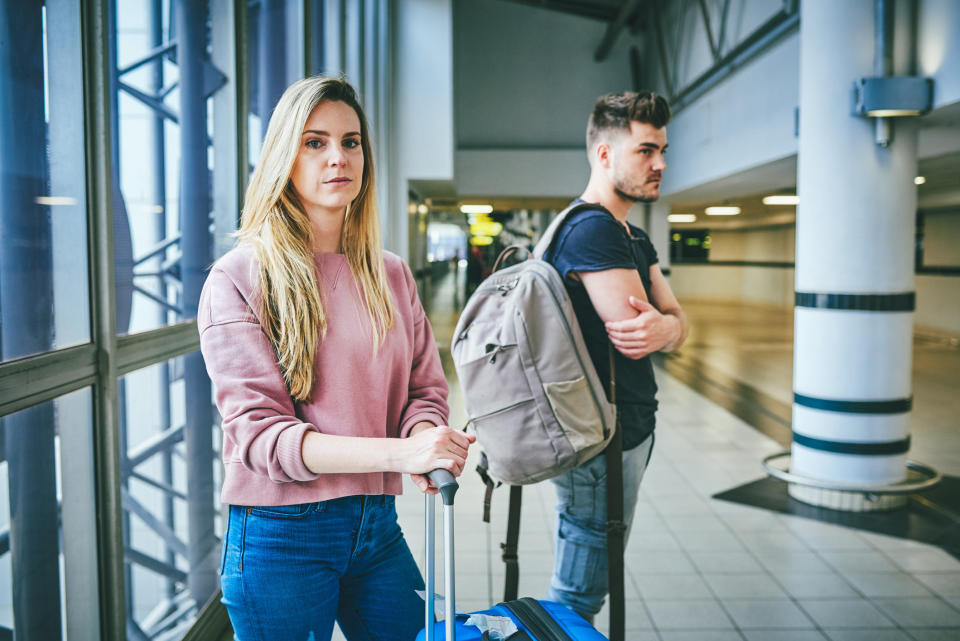 A man and a woman waiting in an airport