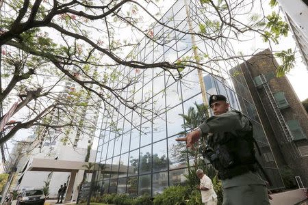 A police officer gestures as he stands guard outside the Mossack Fonseca law firm office in Panama City April 12, 2016. REUTERS/Carlos Jasso