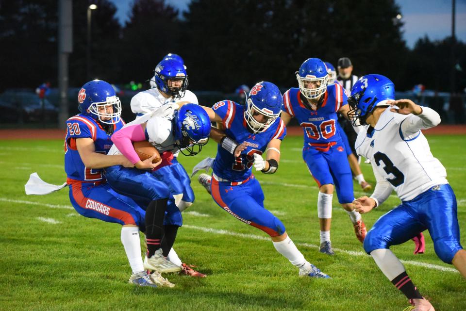 Lenawee Christian's Elijah Lutz (let), Paul Towler (middle) and Seth Davis (right) swarm around Pittsford quarterback Teagan Williams for a sack during Friday's game.