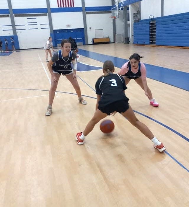 Carlsbad Cavegirls guard Hayden Brose tries to dribble past two teammates during a practice session Dec. 29, 2023 at Carlsbad High School.