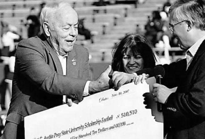 Hendricks Fox and his wife Michele give Austin Peay president Tim Hall a check for $510,510 during halftime of a Governors football game in 2007. Fox made the donation to endow scholarship for Austin Peay football players.