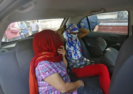 Two veiled Nepali women, who told police they were raped by a Saudi official, sit in a vehicle outside Nepal's embassy in New Delhi, September 9, 2015. REUTERS/Anindito Mukherjee