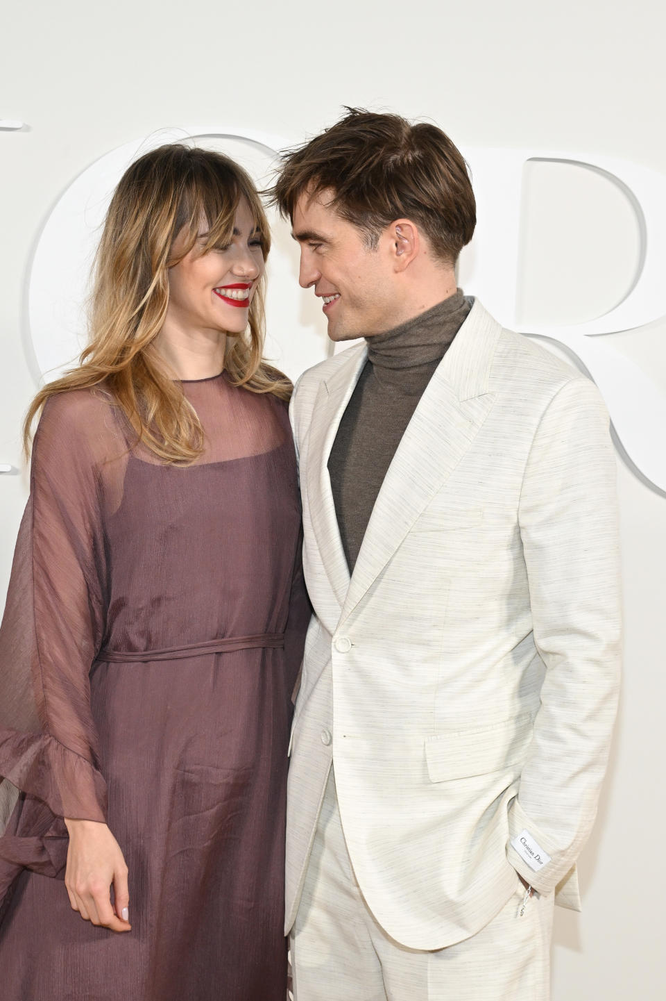 Stock image of Suki Waterhouse and Robert Pattinson looking at each other on the red carpet. (Getty Images)