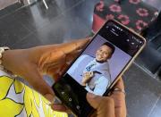 Onomene Adene shows a picture of her brother on a mobile phone during an interview with Reuters in Lagos