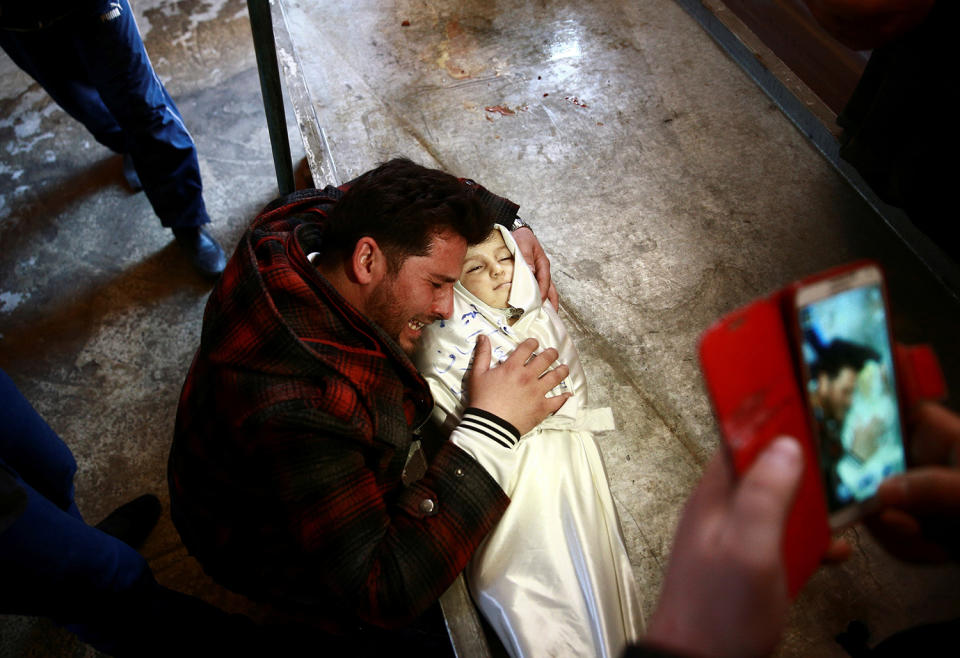 A man reacts over the body of his daughter in Ghouta