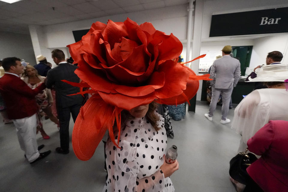 Brittany McKewn, of Asheville, NC, wears a hat shaped like a rose before the 148th running of the Kentucky Derby horse race at Churchill Downs Saturday, May 7, 2022, in Louisville, Ky. (AP Photo/Charlie Riedel)