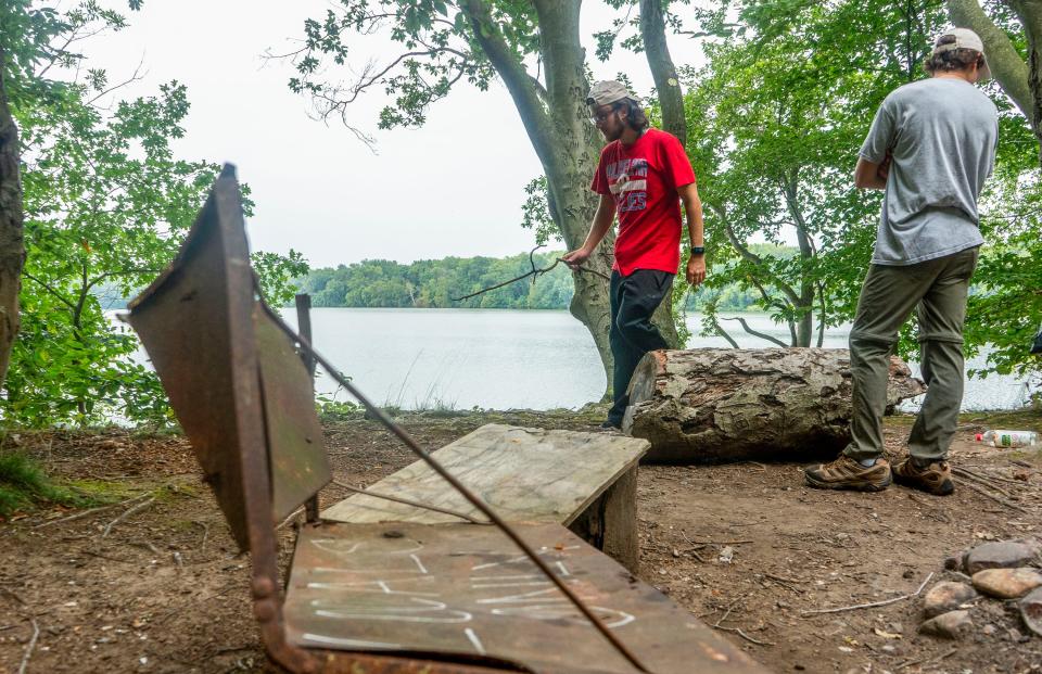 Jarred Colligon, left, from Bristol, with Justin Brown, right, from Yardley, volunteering with Spearhead Project Earth, checks out an area people look to be using as hangout area during their weekly cleanup of Burlington Island on the Delaware River in between New Jersey and Pennsylvania on Thursday, Aug. 10, 2023.