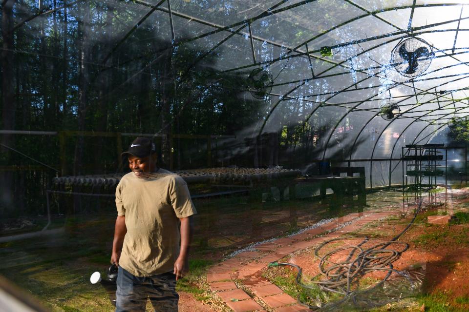 Kevin Light, formerly the house cook, carries a watering can to the greenhouse outside of Soteria House on Monday, April 10, 2023. Soteria granted the men permission and resources to build the greenhouse to provide fresh food to residents.