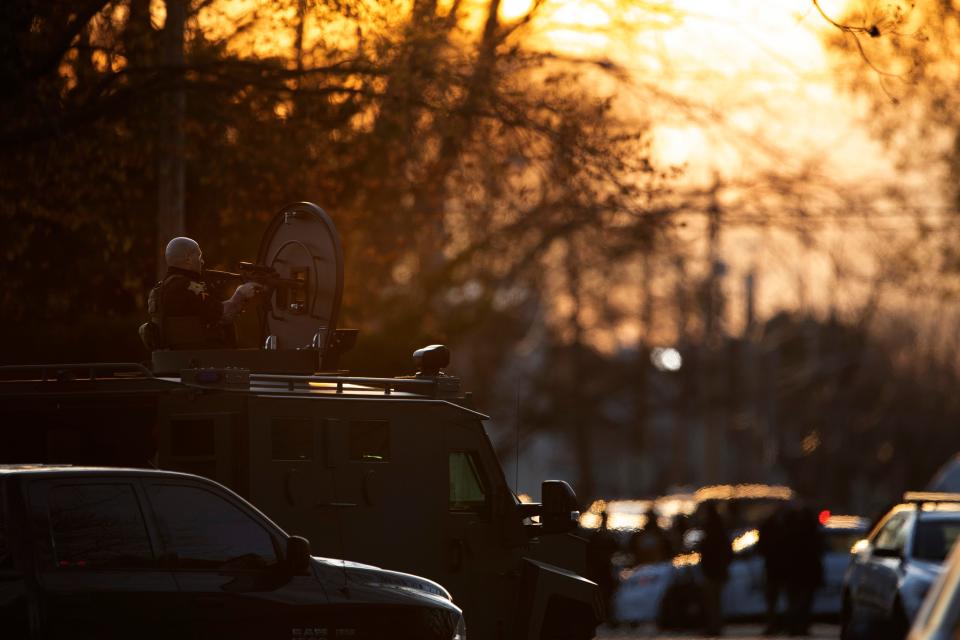 Law enforcement personnel take positions outside a home in the 200 block of E. Missouri Street where Gary Youngblood had barricaded himself Monday evening, March 20, 2023.