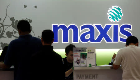 FILE PHOTO: Customers pay bills at a Maxis outlet in Kuala Lumpur November 10, 2009. REUTERS/Bazuki Muhammad/File Photo