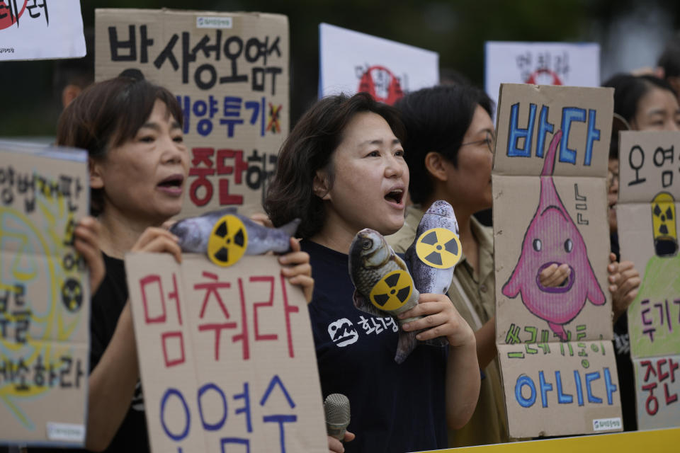 Members of an environmental group shout slogans during a rally to demand the stop of the Japanese government's decision to release treated radioactive water into the sea from the damaged Fukushima nuclear power plant, in Seoul, South Korea, Thursday, Aug. 24, 2023. The letters read " Stop to release radioactive water." (AP Photo/Lee Jin-man)