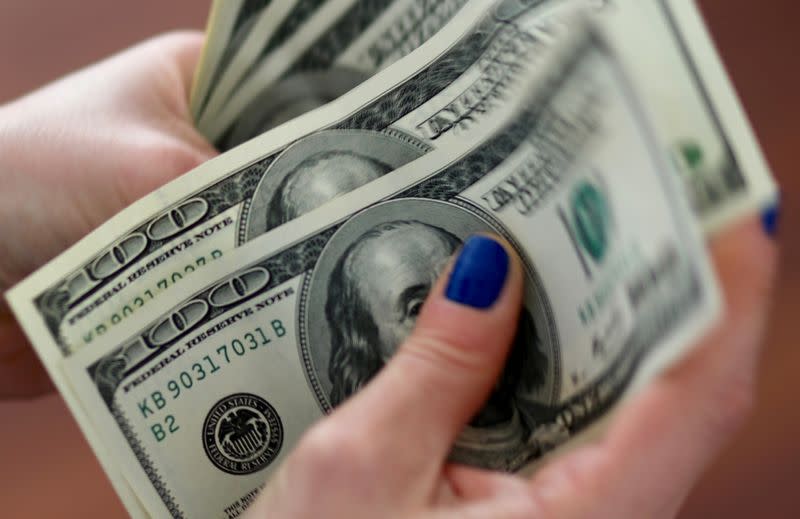 FILE PHOTO: A woman counts U.S. dollar bills at her home in Buenos Aires