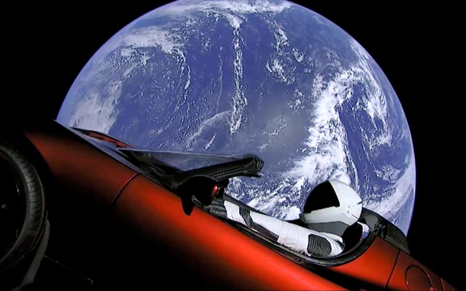 A red Tesla sports car floats through space after being blasted into orbit by Elon Musk's Falcon Heavy rocket - SpaceX