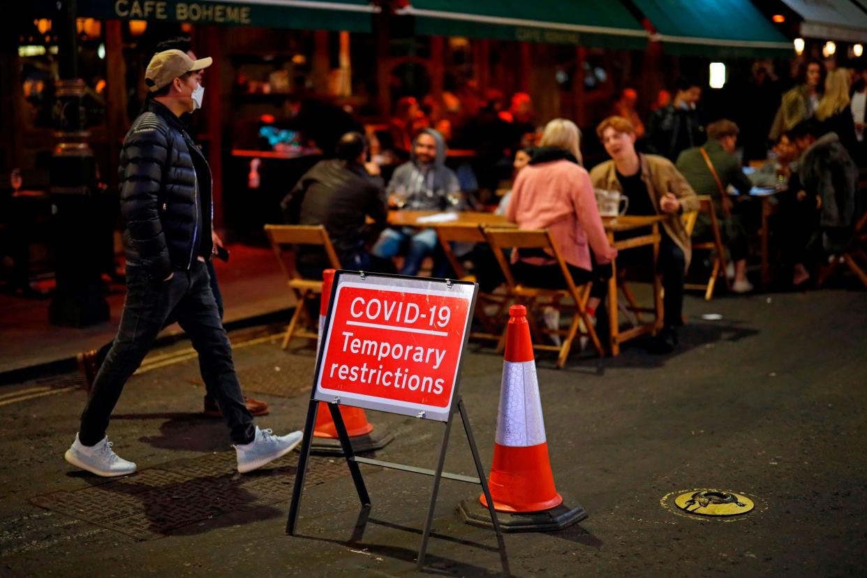 People drink at the outside tables in central London (AFP via Getty Images)