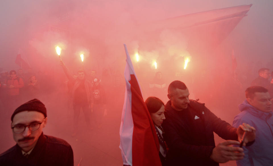 Marchers burn flares as they take part in the annual March of Independence organized by far right activists to celebrate 101 years of Poland's independence, in Warsaw, Poland, Monday, Nov. 11, 2019. (AP Photo/Czarek Sokolowski)