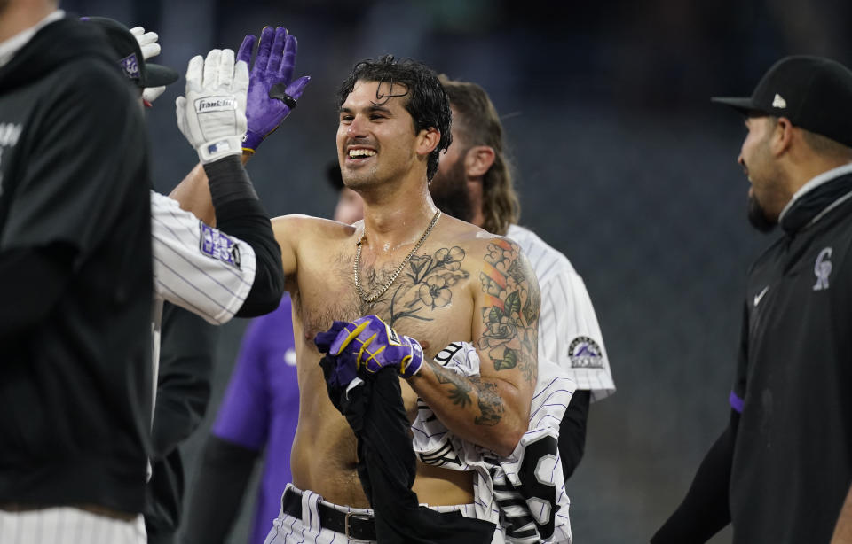 Colorado Rockies' Josh Fuentes, center, is congratulated after he drove in the winning run with a single off San Diego Padres relief pitcher Nick Ramirez during the eighth inning of the second game of a baseball doubleheader Wednesday, May 12, 2021, in Denver. The Rockies won 3-2. (AP Photo/David Zalubowski)