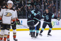 Seattle Kraken defenseman Will Borgen, right, celebrates a goal by left wing Tye Kartye (52) as Anaheim Ducks center Leo Carlsson, left, skates off during the third period of an NHL hockey game Thursday, March 28, 2024, in Seattle. (AP Photo/Jason Redmond)