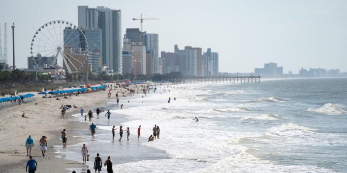 People walk along the beach the morning of May 29, 2021 in Myrtle Beach, South Carolina.