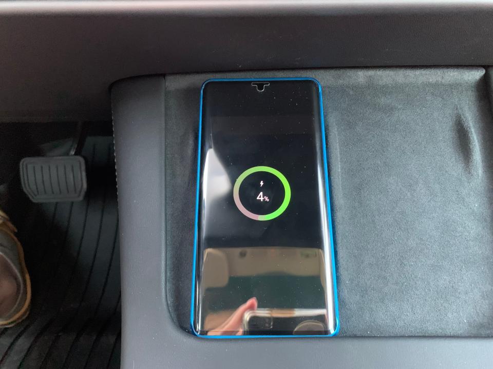 A Samsung phone being charged on the Tesla's charging pad.