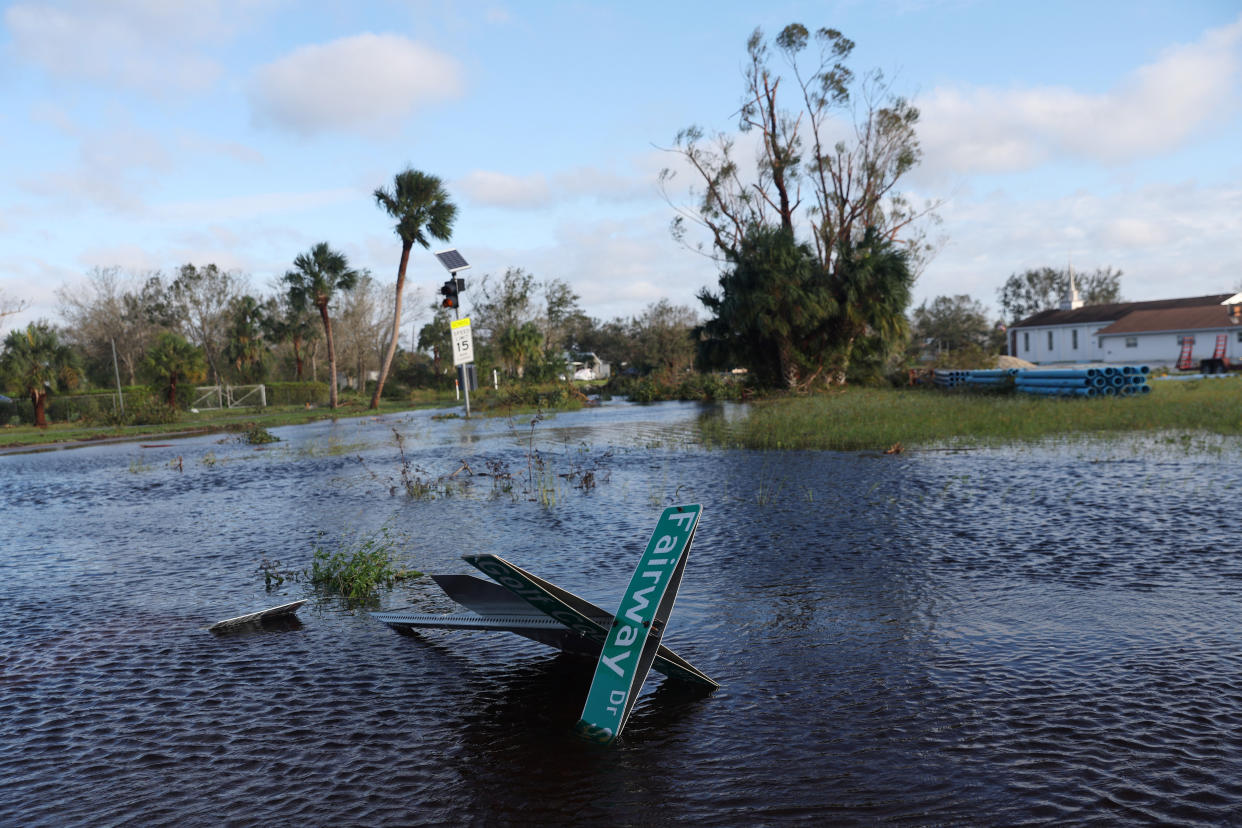 A street sign lies in floodwaters in Punta Gorda, Fla.