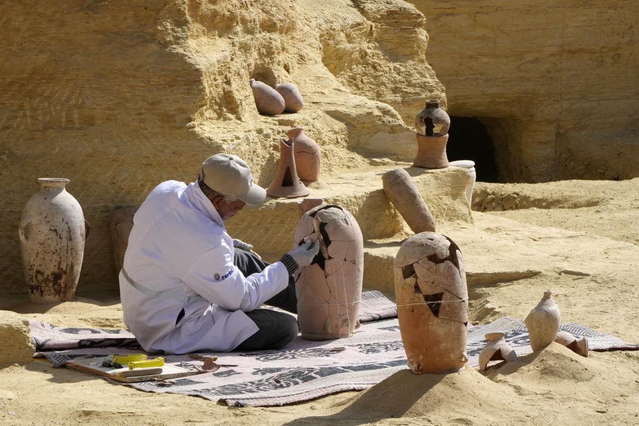An Egyptian archeologist restores a recently discovered pottery at the site of the Step Pyramid of Djoser in Saqqara, 24 kilometers (15 miles) southwest of Cairo, Egypt, Thursday, Jan. 26, 2023. Egyptian archaeologist Zahi Hawass, the director of the Egyptian excavation team, announced that the expedition found a group of Old Kingdom tombs dating to the fifth and sixth dynasties of the Old Kingdom, indicating that the site comprised a large cemetery. (AP Photo/Amr Nabil)