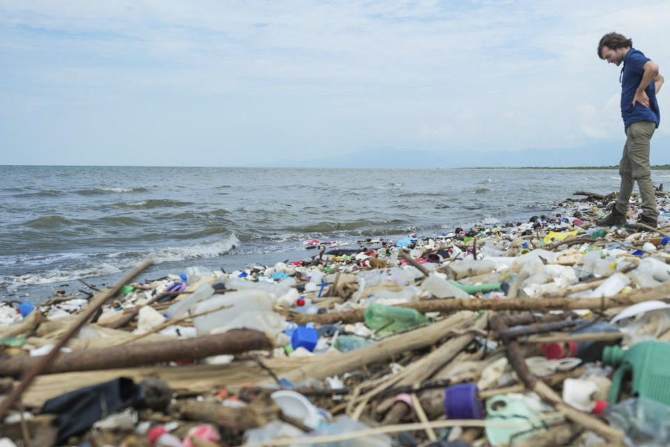 This photo provided by The Ocean Cleanup shows The Ocean Cleanup's founder and CEO Boyan Slat among the trash on the Rio Motagua in Guatemala in 2022. (The Ocean Cleanup via AP)