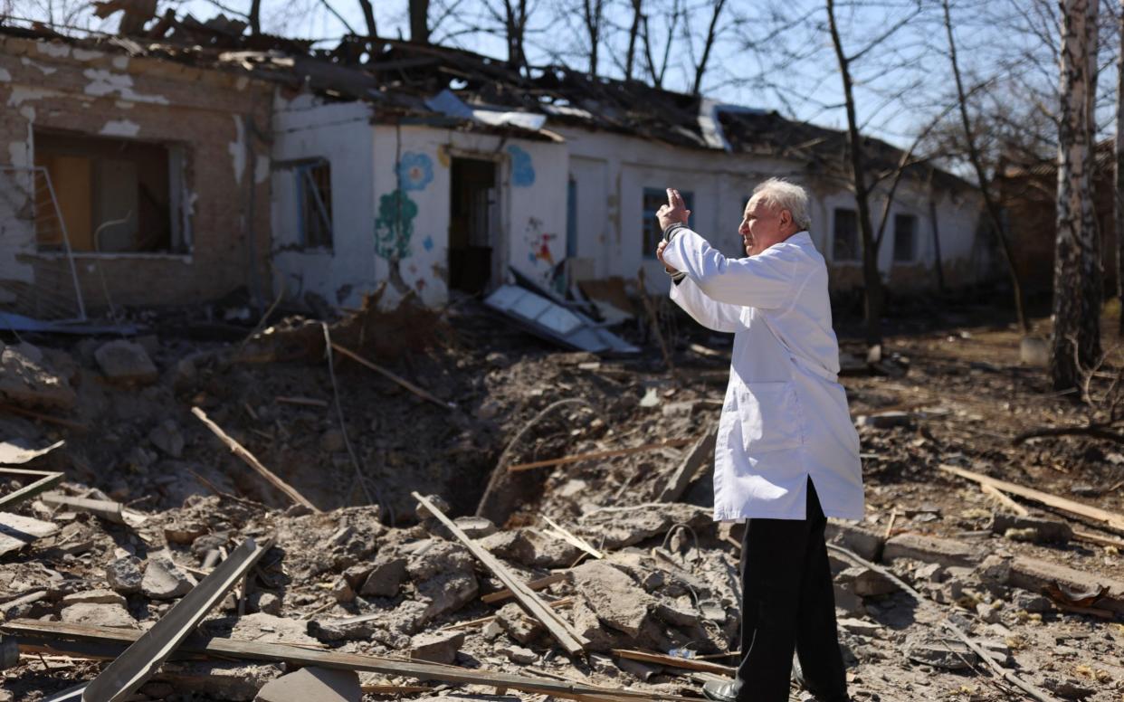 Doctor Anatolii Pavlov takes pictures of a damaged psychiatric hospital after it was hit in a military strike, as Russia's invasion of Ukraine continues, in Mykolaiv - Nacho Doce/Reuters