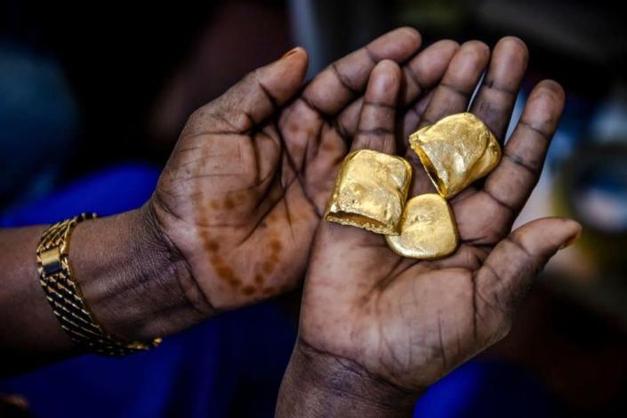 Tanzanian miner Assia Hussein, who is the chairman of an only-women miners association, observes some pure gold nuggets at a gold market in Geita, Tanzania on May 28, 2022. Tanzania is a land rich in minerals and one of the main gold producers in Africa, with gold representing more than 90% of the country's mineral exports. Artisanal and small-scale gold mining have culturally and historically relegated women's participation. The extractive sector in Tanzania has historically been a male-dominated industry with high levels of harassment, sexual abuse, discrimination and misconceptions over women's involvement,