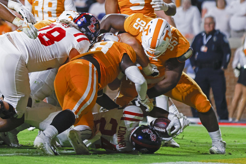 Mississippi running back Snoop Conner (24) scores a touchdown as he's hit by Tennessee defensive lineman Da'Jon Terry (95) and defensive lineman Ja'Quain Blakely (48) during the first half of an NCAA college football game Saturday, Oct. 16, 2021, in Knoxville, Tenn. (AP Photo/Wade Payne)