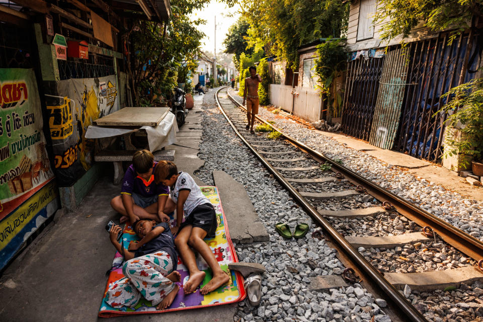 Children take a nap in the shade near the train tracks in the Khlong Toei district of Bangkok, Thailand, May 1, 2024. / Credit: Lauren DeCicca/Getty
