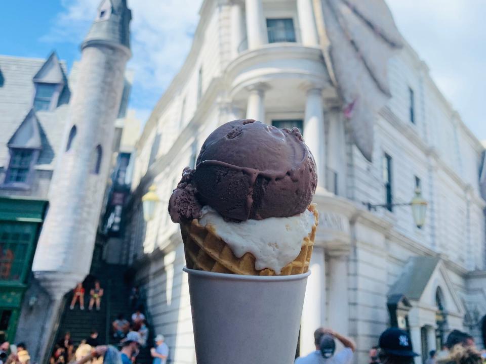 hand holding ice cream cone in front of gringotts bank at universal studios orlando