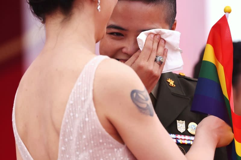 Wang Yi, a political warfare major from the army, wipes away tears during a military mass wedding in Taoyuan,