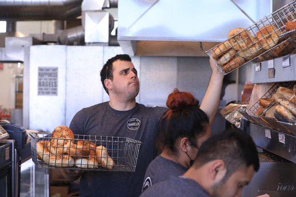 Eastdale Avenue Bagels owner, Alex Maravegias replenishes the the baskets of bagels on February 21, 2022.