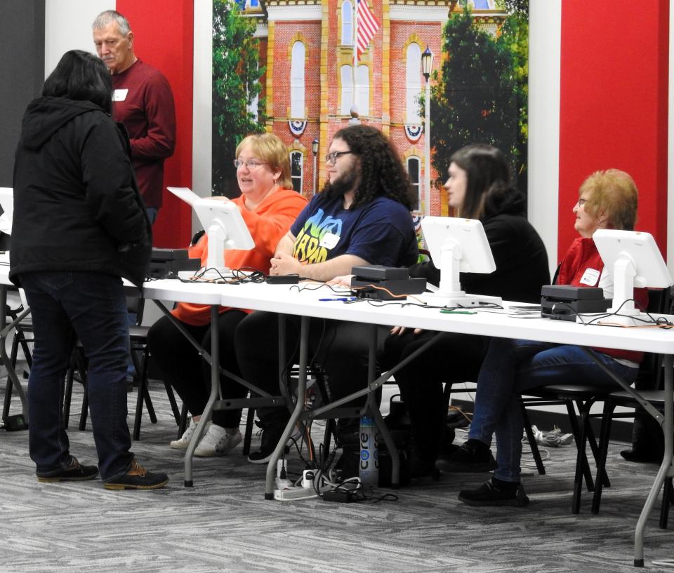 Poll worker help a voter to sign in for Tuesday's primary election at the Coshocton County Commissioners Community Meeting Room.