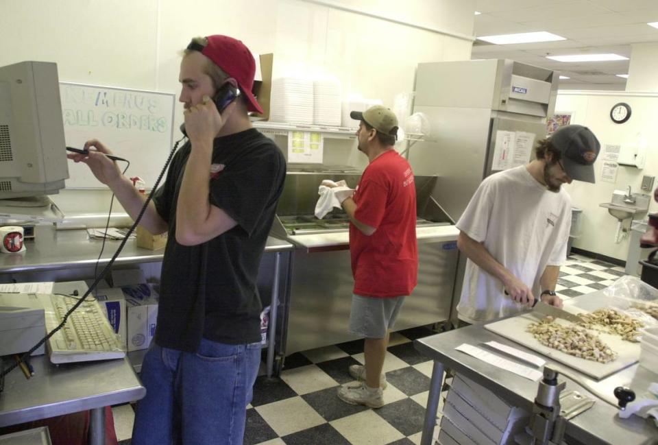 The popular carry-out pizza shop Capital Creations will close next month after more than 30 years in Raleigh. Pictured are Capital Creations employees working a busy Friday lunch shift in 2003.