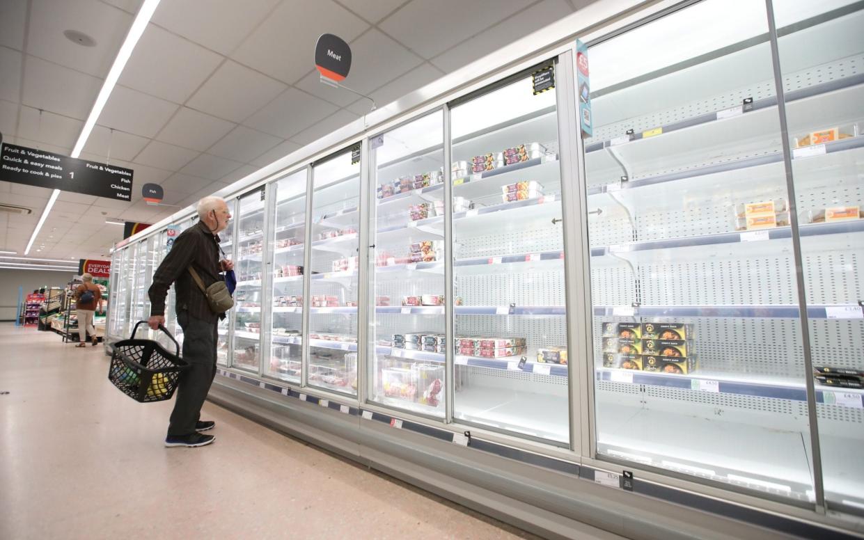 A shopper looks at empty shelves in the Co-Op supermarket, Harpenden - Reuters