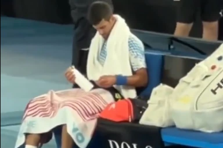 Novak Djokovic examina la botella con un misterioso mensaje