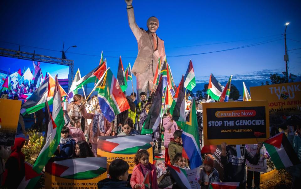 Palestinians carrying flags and banners gather at the Nelson Mandela Square in Ramallah, West Bank to demonstrate in support of the 'genocide' case filed by South Africa against Israel