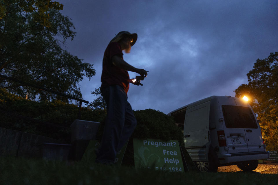 Chris, a sidewalk counselor with the anti-abortion group, A Moment of Hope, who only gave his first name, arrives before sunrise to set up for the day outside the Planned Parenthood clinic where patients will be arriving for abortion appointments Friday, May 27, 2022, in Columbia, S.C. The presence of Planned Parenthood in this office park would be barely noticeable save for the throng of foes it attracts. Those drawn here to this fight, the ones who set their alarms for 3:35 a.m. and left their spouse and children behind an hour away, are focused on the task at hand: To change a single mind and, in their eyes, save a single life. (AP Photo/David Goldman)