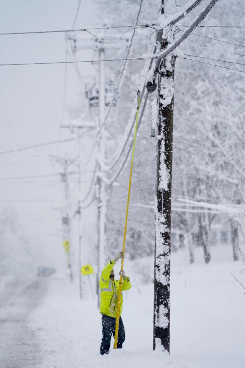 A contractor for Eversource uses a fiberglass pole to replace a fuse that broke on Tuesday in Pittsfield, Mass.