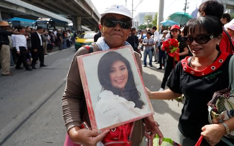 Supporters of ousted former Thai prime minister Yingluck Shinawatra wait for her at the Supreme Court in Bangkok - Credit: REUTERS